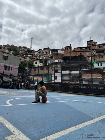 Image of a kid sitting on a basket ball at Comuna Trece